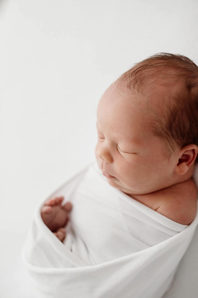 newborn-kuvaus-helsinki Vastasyntynyt vauva newbornkuvauksessa aidin sylissa.